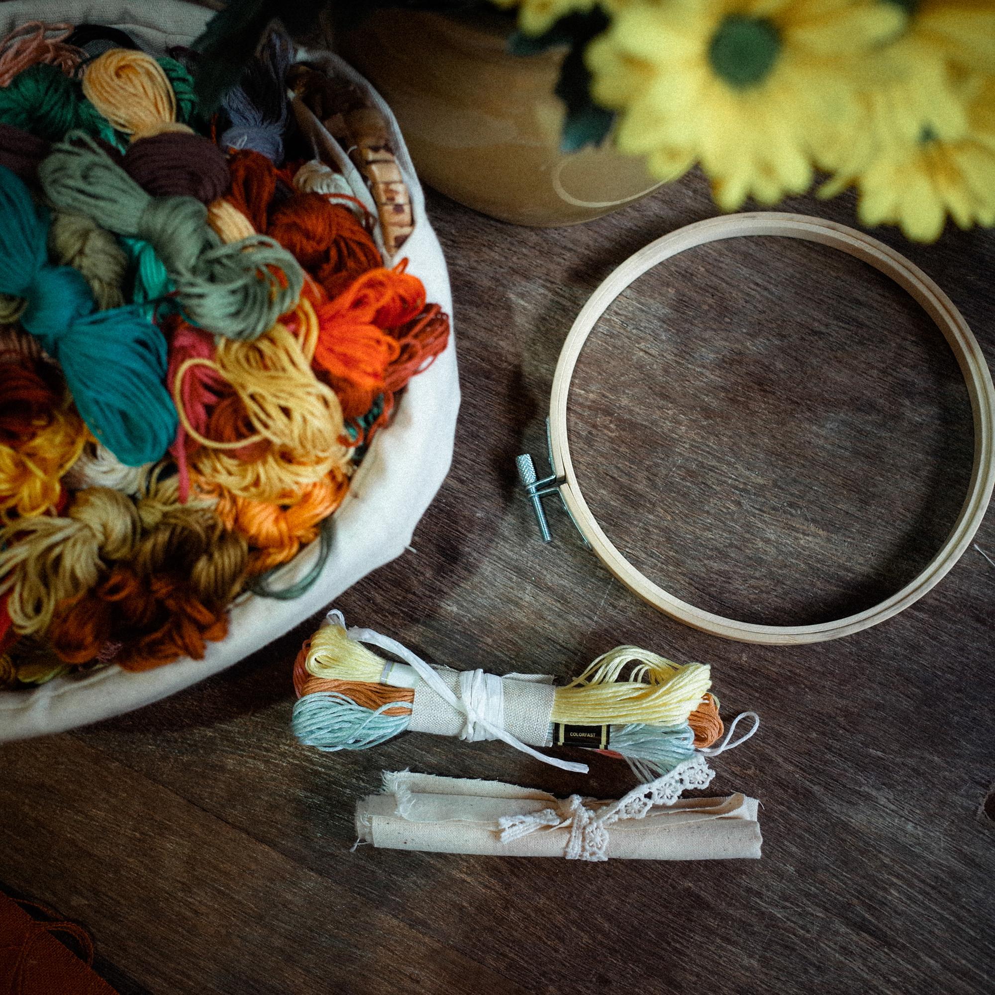 studio table with threads and embroidery hoop